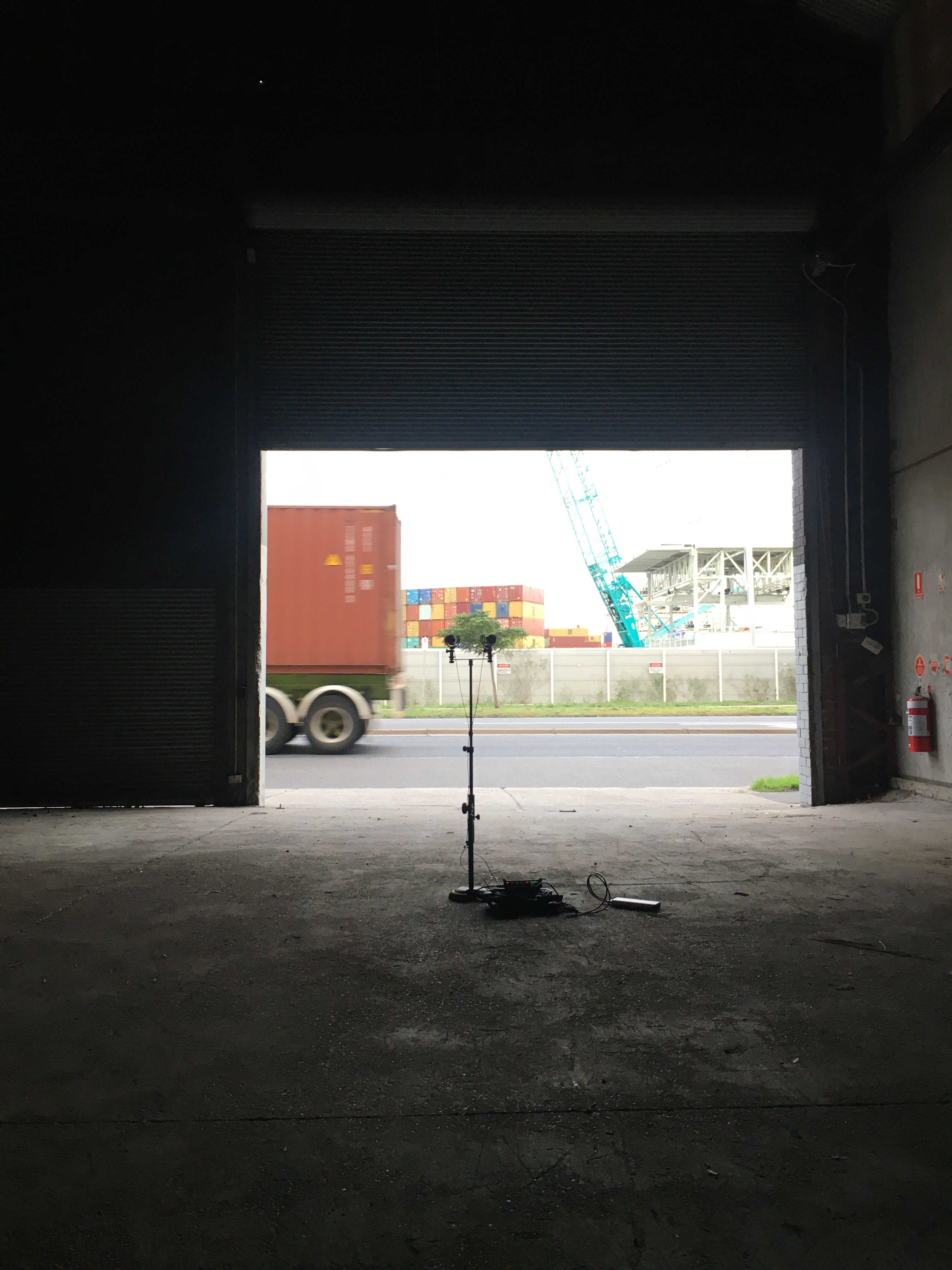 A stereo pair of microphones recording pointed out a warehouse door in Yarraville, Melbourne as a truck drives past